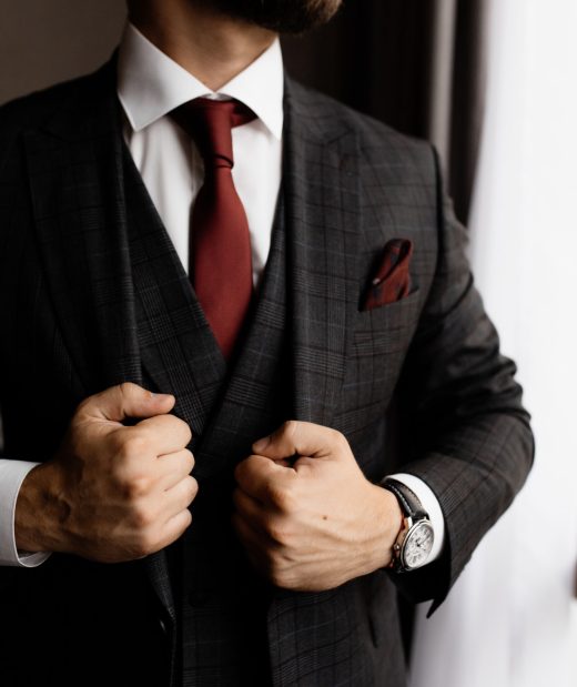 Bearded man in stylish tuxedo and red tie, strong man's hands